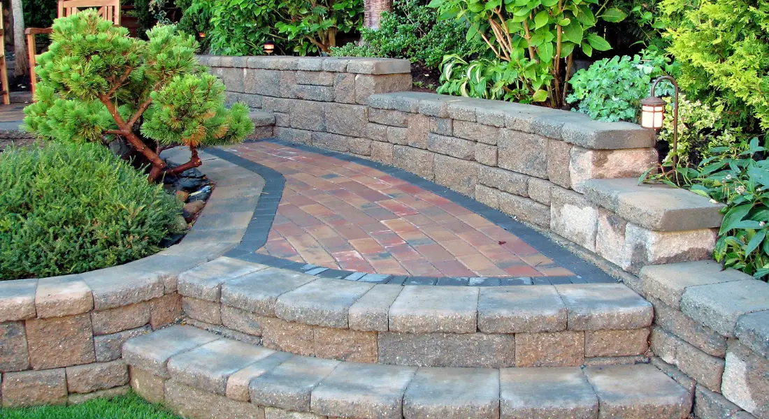brick patio with curved stone retaining walls and garden landscaping