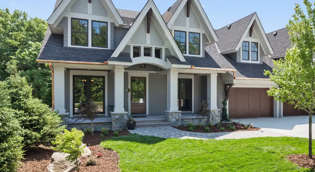 front yard of a modern suburban home with fresh landscaping, green lawn, and trimmed shrubs